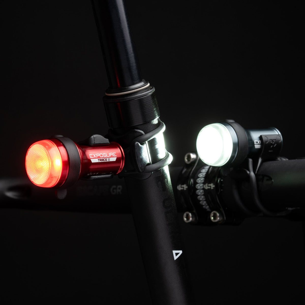 Exposure Trace and TraceR Mk4 lights both switched on, white at the front and red at the rear, in the dark