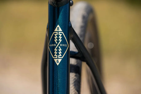 Gold Marin Bikes diamond badge on the metallic teal frame of the Gestalt 1