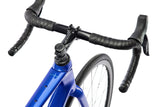 Close-up of a blue bicycle with black handlebars on a white background