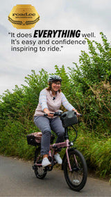 Woman riding rose gold estarli E20.7 Comfort Hybrid E-Bike with quote praising its ease and confidence-inspiring ride quality.