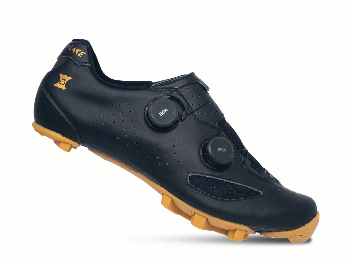 Black cycling shoe with yellow sole on a white background