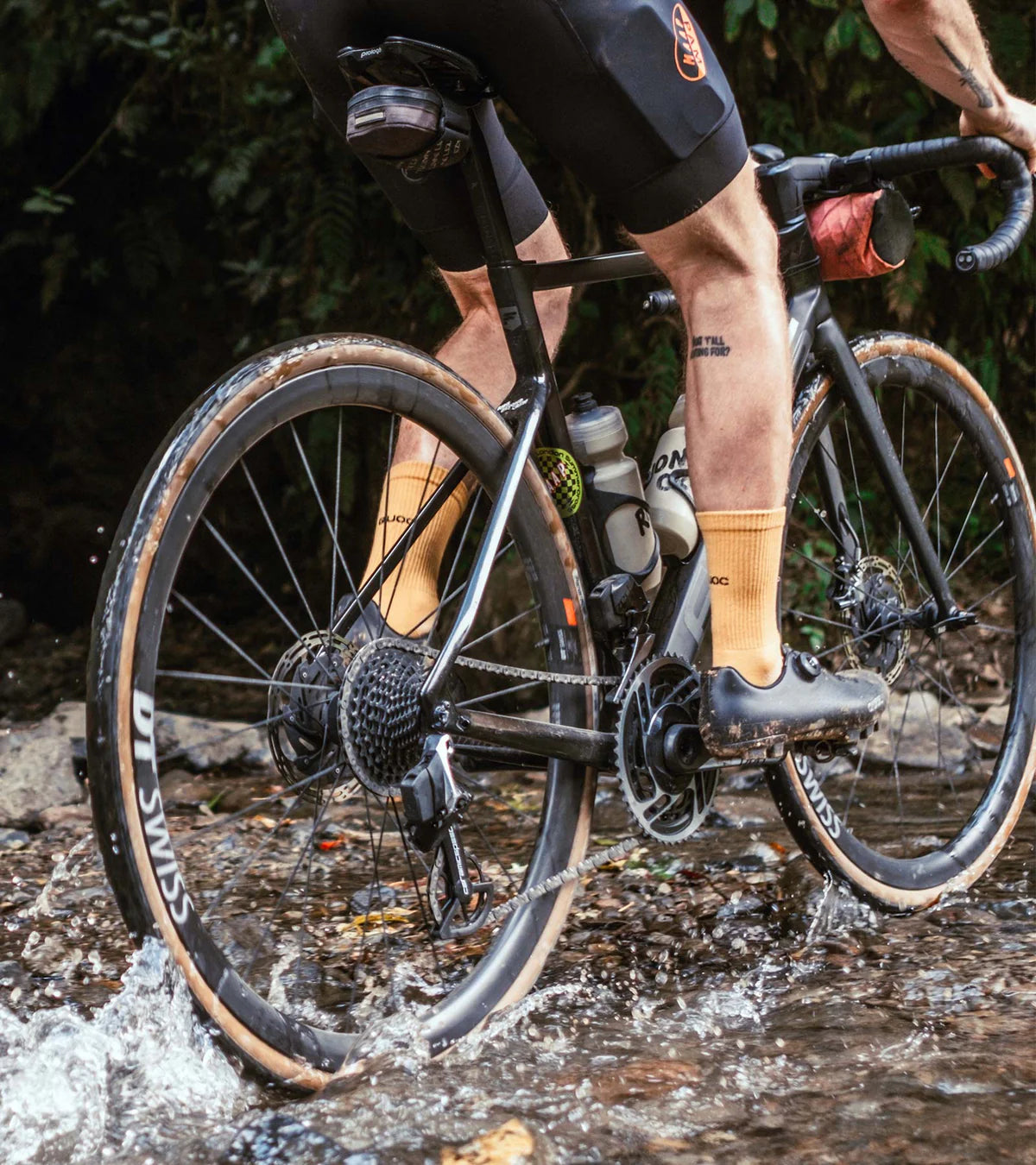 QUOC Escape Off-Road Shoe in black used while cycling through water, highlighting traction and waterproof features.