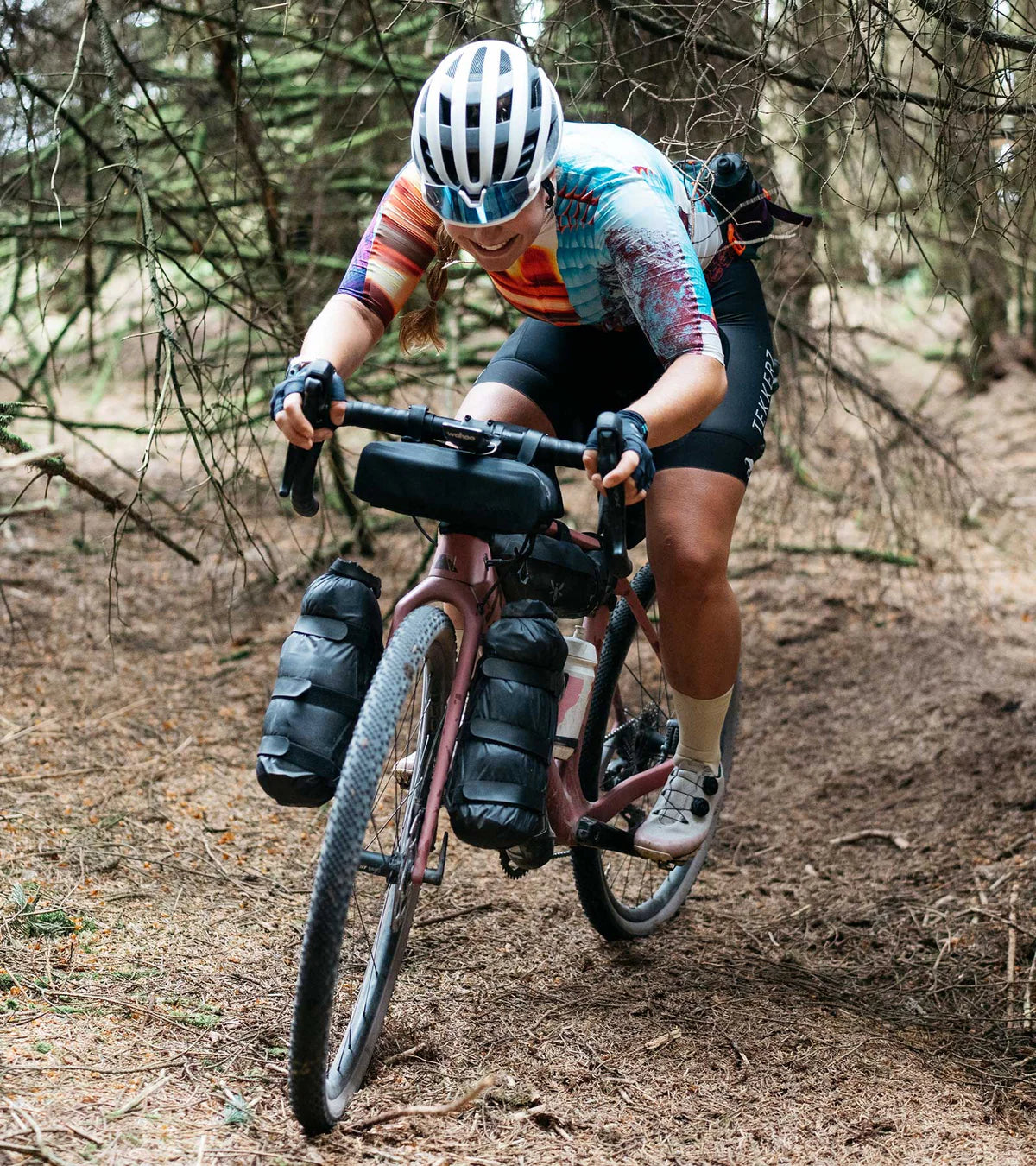 Cyclist climbing a forest trail wearing QUOC Gran Tourer XC Off-Road Shoes, demonstrating their durability and off-road traction.