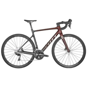 The Addict 30 Red Road Bike by Scott features a sleek dark maroon and black frame with drop handlebars, thin tires, and disc brakes. The branding prominently reads "Scott" on the frame, and the bike's saddle is positioned for an aerodynamic riding posture.