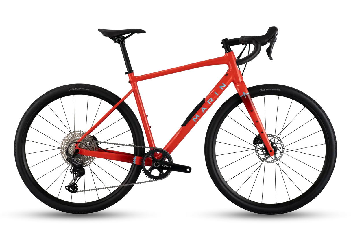 A red Marin road/gravel bicycle with black components, drop handlebars, and disc brakes, shown from a side profile on a white background.