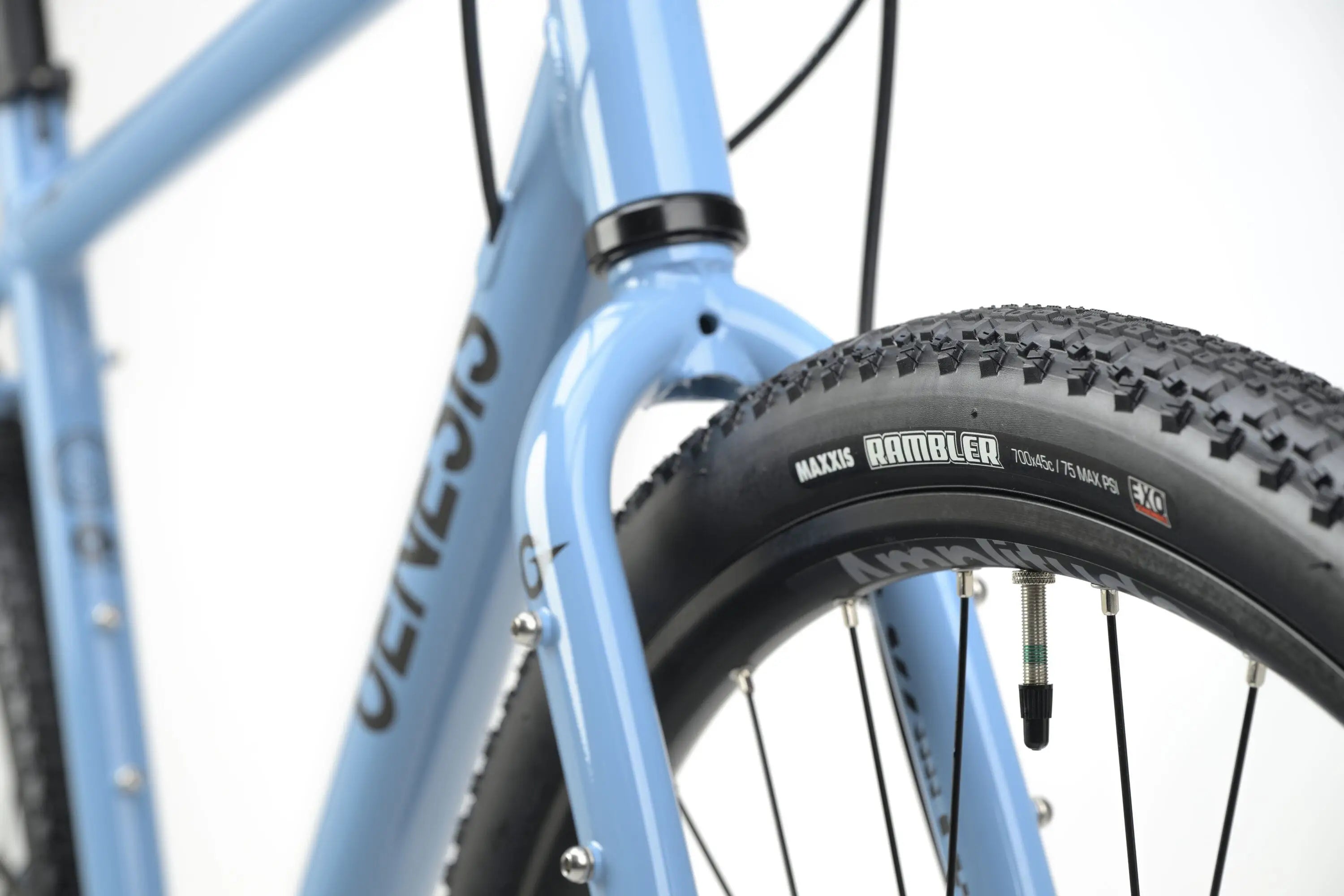 Light blue Genesis CDA 10 gravel bike frame detail with black tire and knobby tread.