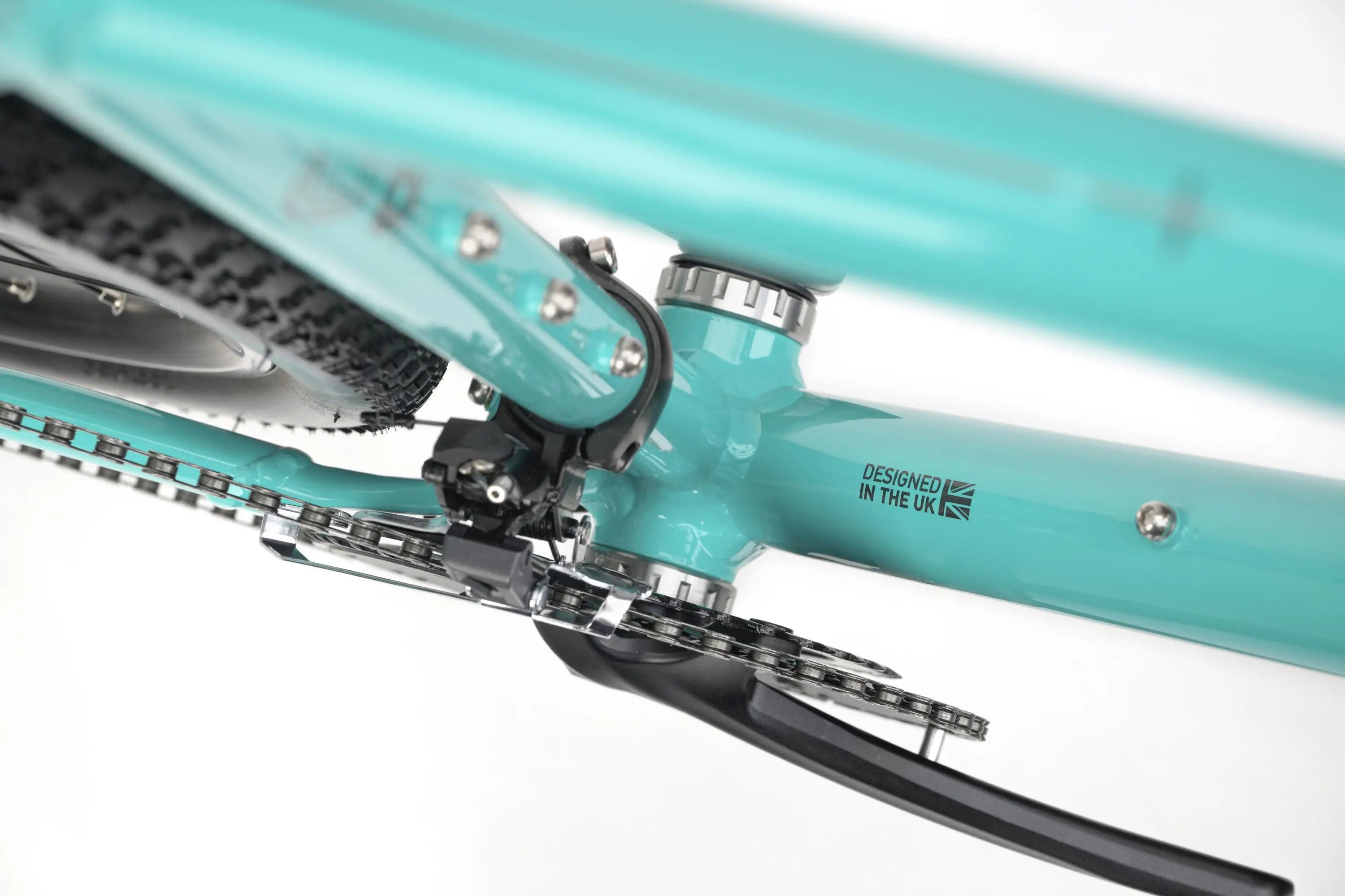 Close-up of teal Genesis CDA 20 gravel bike frame showing bottom bracket, chainstay, and part of the drivetrain.