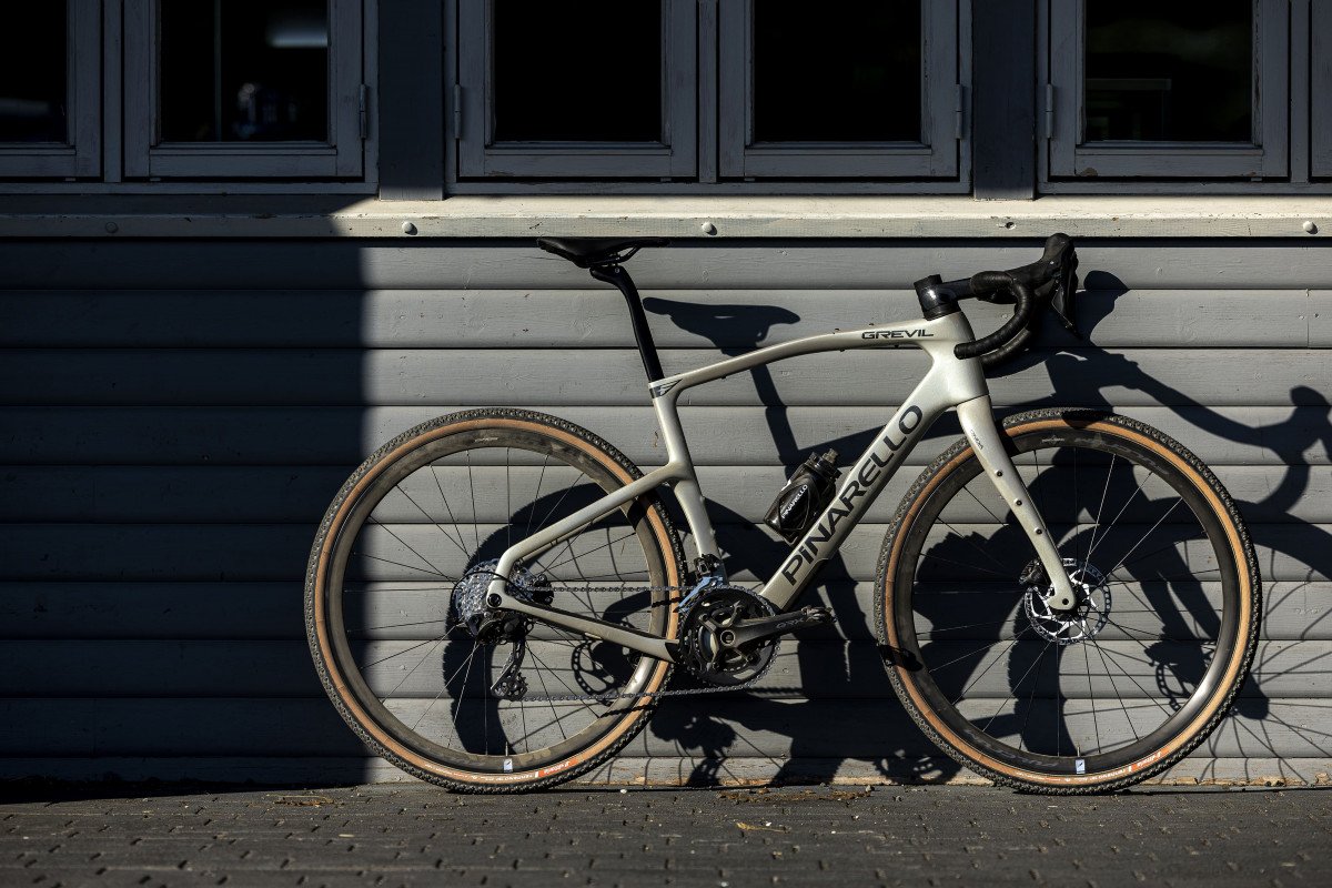 White bicycle with 'Pivotal' branding leaning against a gray building.