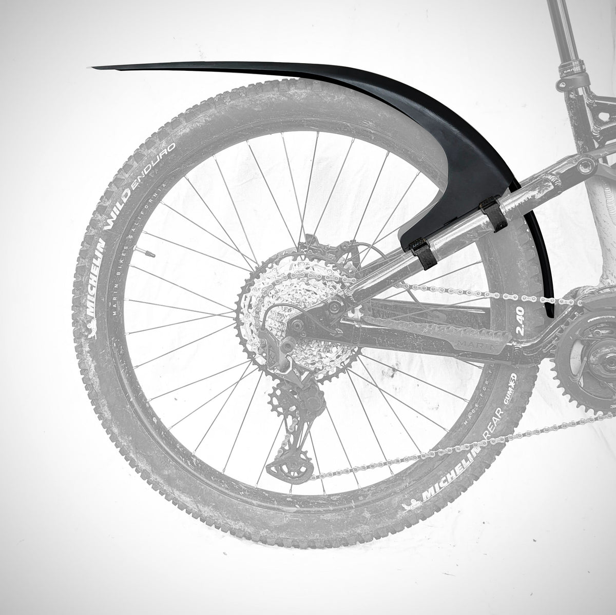 Mudhugger MK2 rear mudguard shown in position above the rear wheel of a mountain bike on a white background