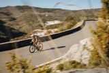 Purple and blue Merida Scultura Endurance 9000 road bike on winding mountain road.