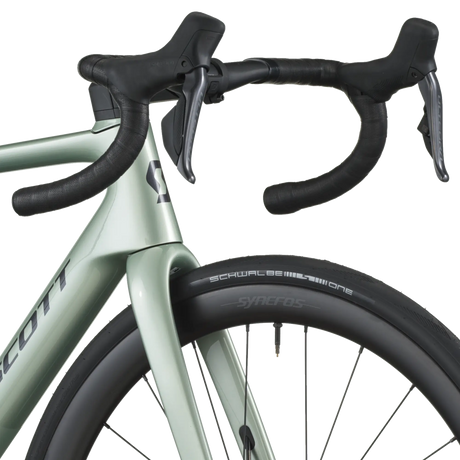 Close-up of a bicycle handlebar and front wheel on a white background