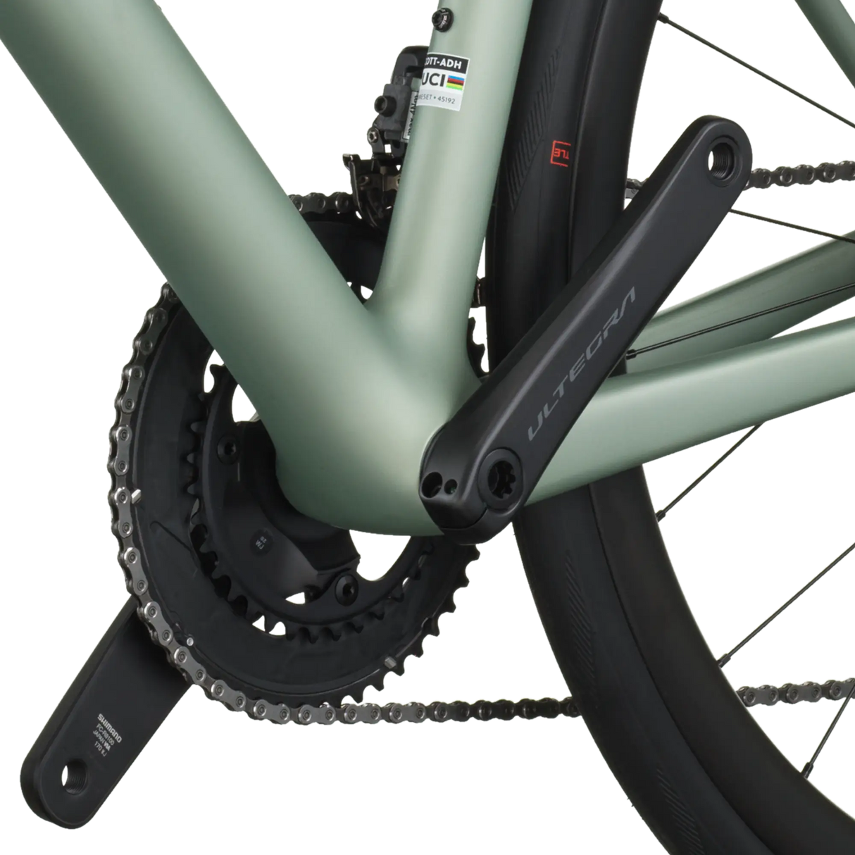 Close-up of a bicycle chain and gear system on a light green frame.