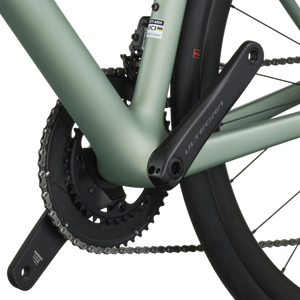 Close-up of a bicycle chain and gear system on a light green frame.
