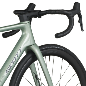 Close-up of a green bicycle with black handlebars on a white background