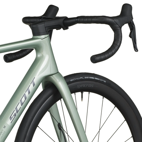 Close-up of a green bicycle with black handlebars on a white background
