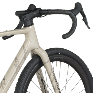 Close-up of a bicycle with beige frame and black tires on a white background