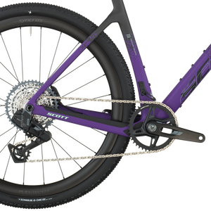 Close-up of a purple bicycle with visible brand logos on a white background