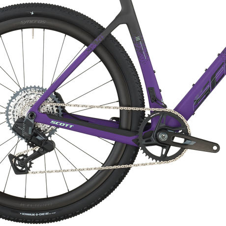 Close-up of a purple bicycle with visible brand logos on a white background