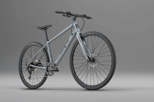 Whyte RHeO 0 hybrid bike in dark silver from a front three-quarter angle, showing the flat bar and front disc brake.