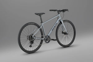 Whyte RHeO 0 hybrid bike in dark silver from a rear three-quarter angle, showing the 1x9 Shimano CUES drivetrain.